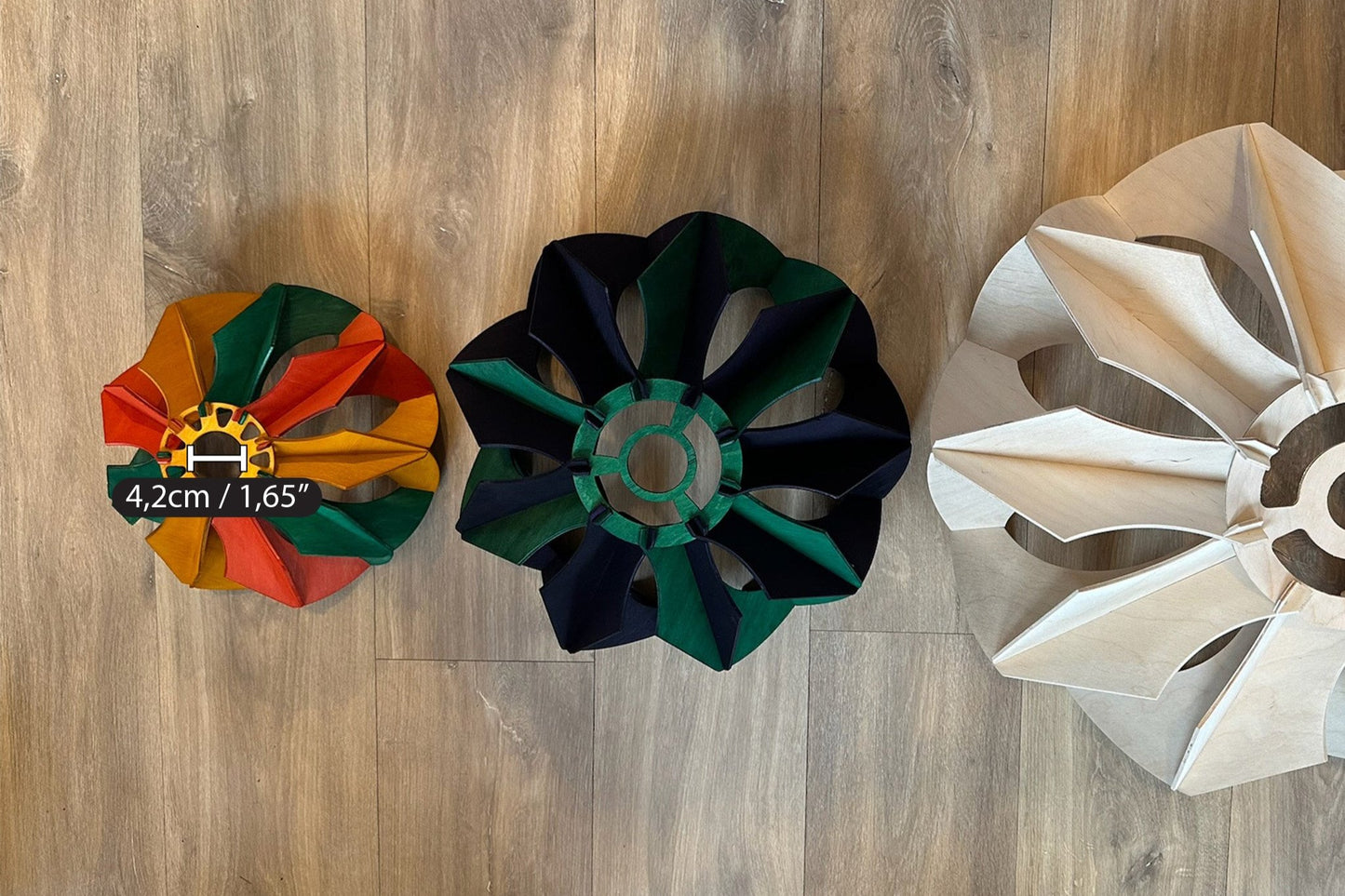 Top-down view of three pendant lamps of varying sizes, with the smallest stained in green, yellow ochre, and scarlet, displaying the flower-like design and the central opening, with the small one having a 4.2cm (1.65") diameter hole.