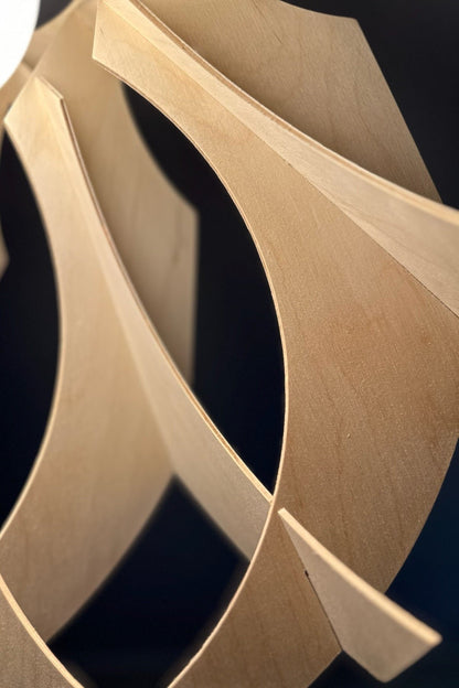 A close-up view of the edges of the wooden lamp, showcasing the smooth, precise cuts and the natural wood texture. The lamp’s design combines modern and rustic elements.