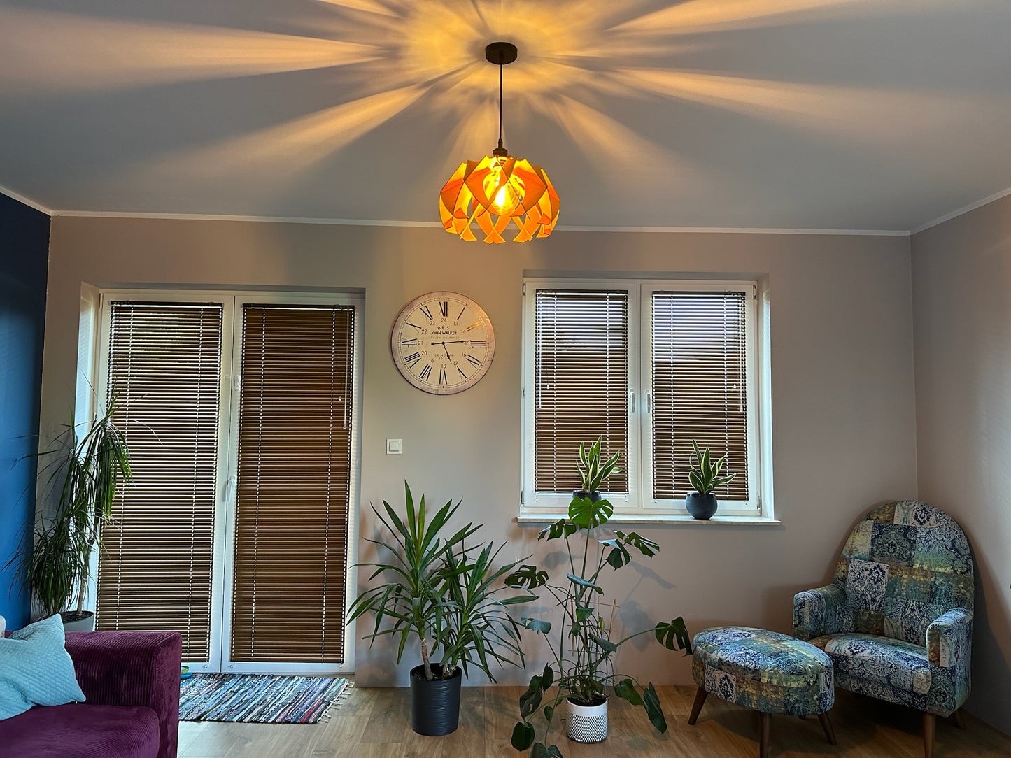 Wooden pendant lamp illuminating a living room, featuring a flower-shaped design that creates a beautiful ambiance, ideal for modern and rustic interiors.